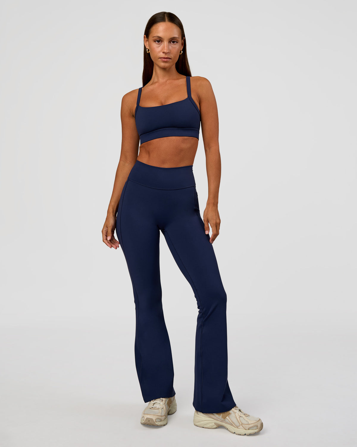 Woman wearing Fusion V-Contour High-Rise Flared Petite Legging Pockets - Future Navy | Model:Brylee | Size:XS