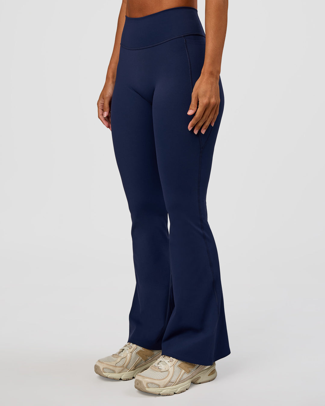 Woman wearing Fusion V-Contour High-Rise Flared Petite Legging Pockets - Future Navy | Model:Brylee | Size:XS