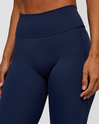 Woman wearing Fusion V-Contour High-Rise Flared Petite Legging Pockets - Future Navy | Model:Brylee | Size:XS