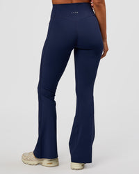 Woman wearing Fusion V-Contour High-Rise Flared Petite Legging Pockets - Future Navy | Model:Brylee | Size:XS