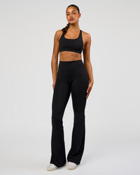 Woman wearing Fusion V-Contour High-Rise Flared Tall Legging Pockets - Black | Model:Rosie | Size:S