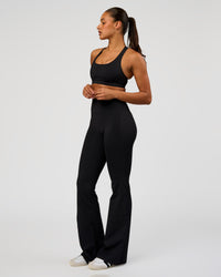 Woman wearing Fusion V-Contour High-Rise Flared Tall Legging Pockets - Black | Model:Rosie | Size:S