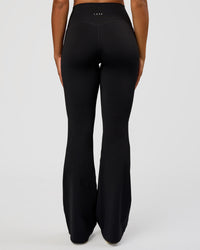 Woman wearing Fusion V-Contour High-Rise Flared Tall Legging Pockets - Black | Model:Rosie | Size:S