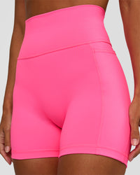 Woman wearing Fusion V-Contour Ultra High-Rise 4” Short Pockets - Sugar Plum | Model:Brylee | Size:XS