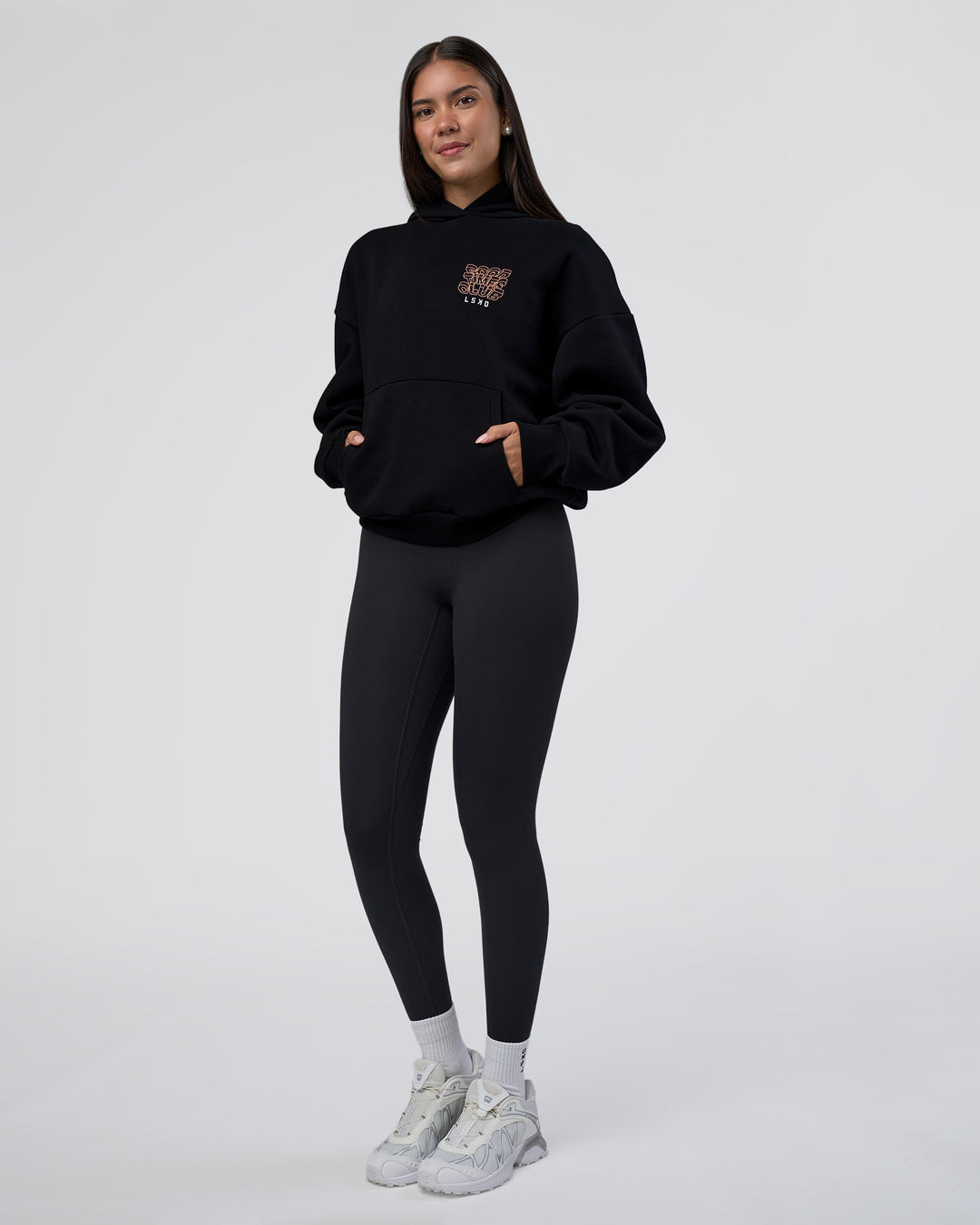 Woman wearing GTC CVC Fleece Unisex Oversized Hoodie - Black-Cantaloupe | Model:Rhiley | Size:XS