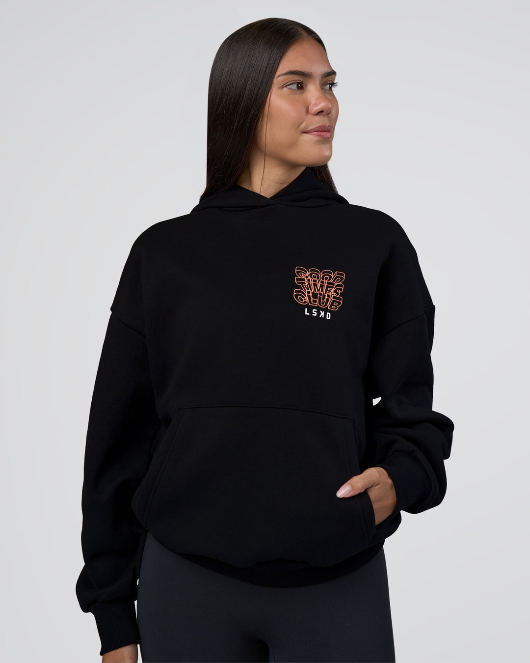 Woman wearing GTC CVC Fleece Unisex Oversized Hoodie - Black-Cantaloupe | Model:Rhiley | Size:XS