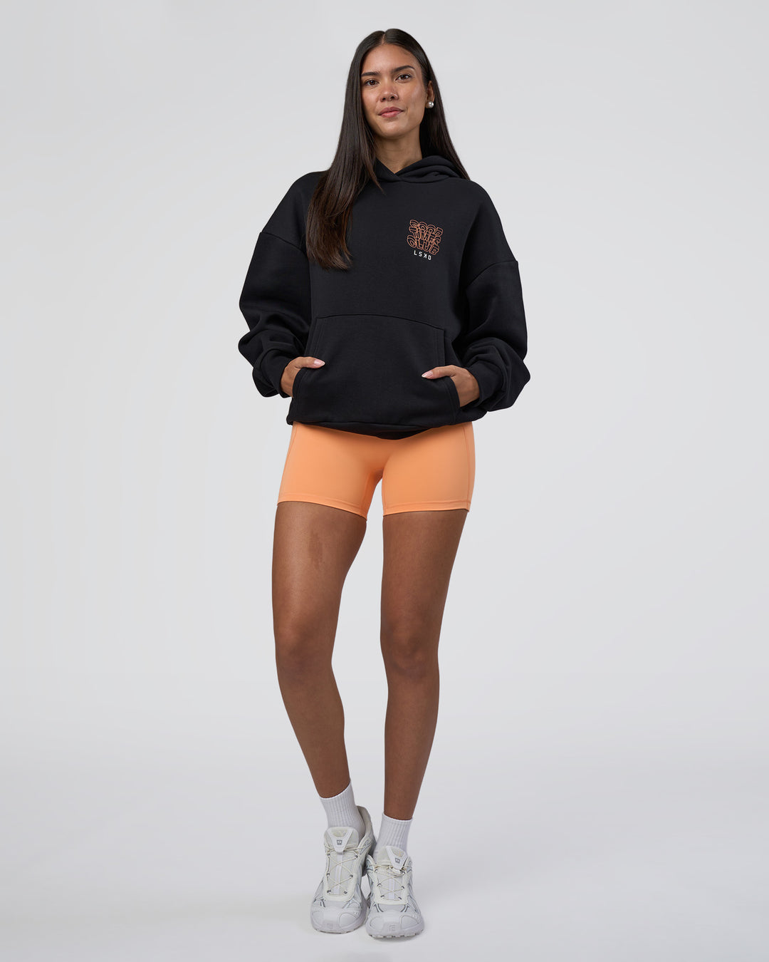 Woman wearing GTC CVC Fleece Unisex Oversized Hoodie - Black-Cantaloupe | Model:Rhiley | Size:XS