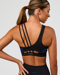 Woman wearing Galvanise Hype Graphic Sports Bra 2.0 - Black-Electric Indigo | Model:Charli | Size:XS