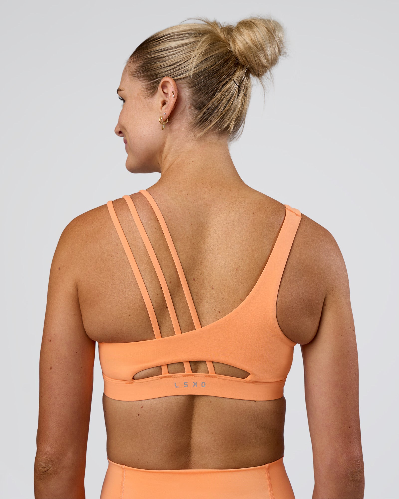 Woman wearing Galvanise Splice Sports Bra - Cantaloupe | Model:Emelia | Size:XS