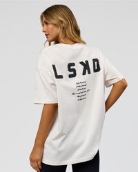 Woman wearing Hype Heavyweight Unisex Oversized Tee - Off White-Black | Model:Leilani | Size:XS