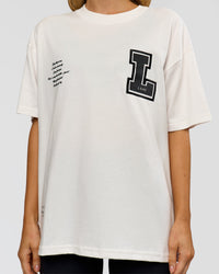 Woman wearing Hype Heavyweight Unisex Oversized Tee - Off White-Black | Model:Leilani | Size:XS