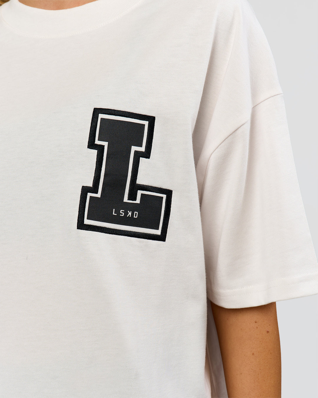 Woman wearing Hype Heavyweight Unisex Oversized Tee - Off White-Black | Model:Leilani | Size:XS
