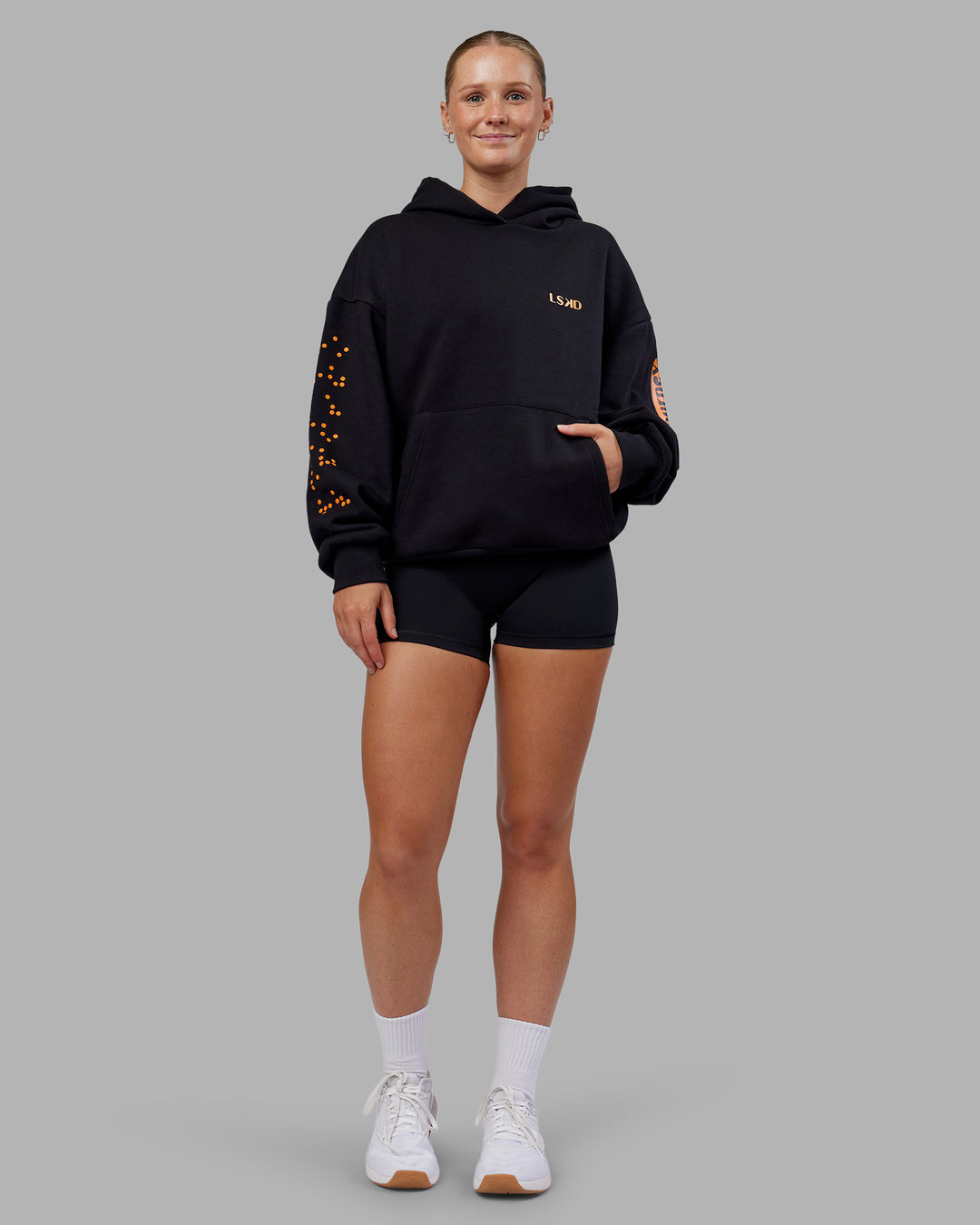 Woman wearing Hyped Unisex Oversized Hoodie - Black-Vibrant Orange | Model:Neve | Size:XS