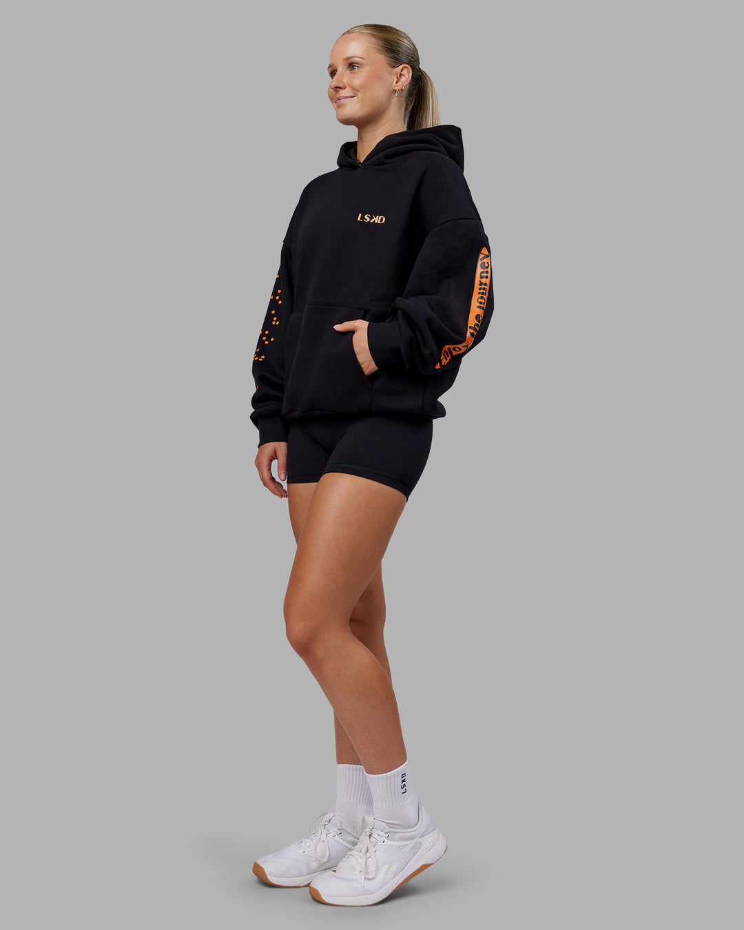 Woman wearing Hyped Unisex Oversized Hoodie - Black-Vibrant Orange | Model:Neve | Size:XS