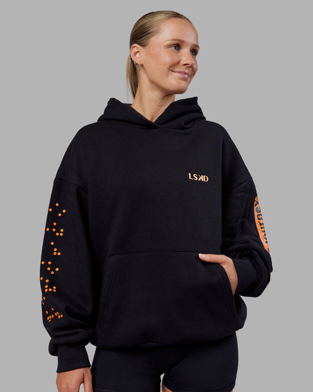 Woman wearing Hyped Unisex Oversized Hoodie - Black-Vibrant Orange | Model:Neve | Size:XS