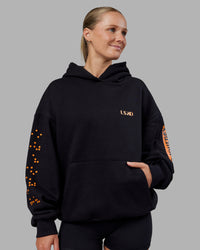 Woman wearing Hyped Unisex Oversized Hoodie - Black-Vibrant Orange | Model:Neve | Size:XS