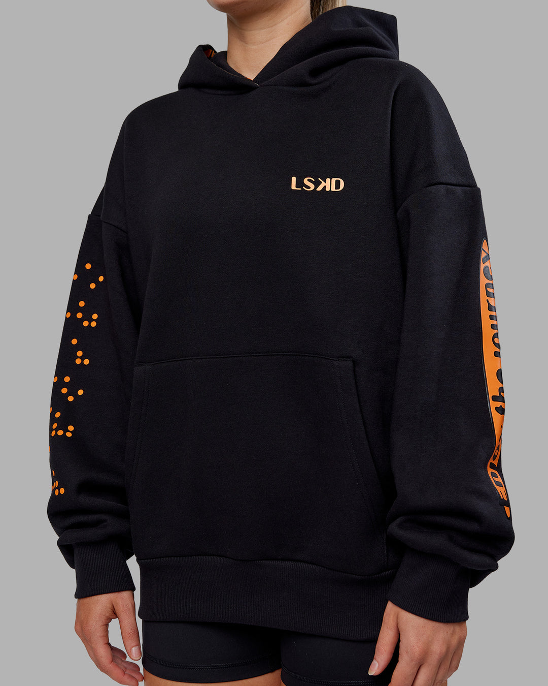 Woman wearing Hyped Unisex Oversized Hoodie - Black-Vibrant Orange | Model:Neve | Size:XS