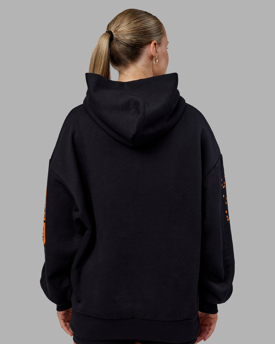 Woman wearing Hyped Unisex Oversized Hoodie - Black-Vibrant Orange | Model:Neve | Size:XS