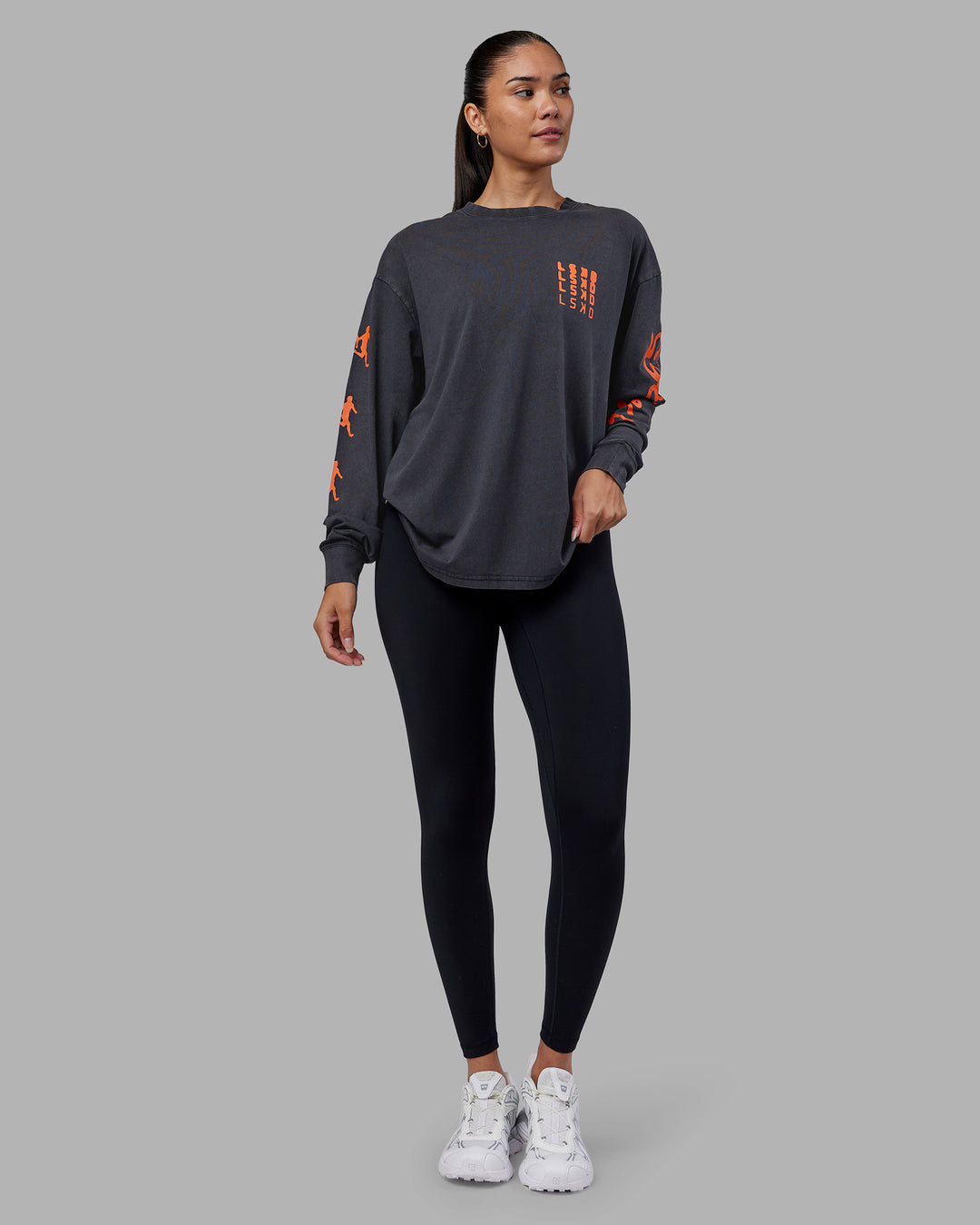 Woman wearing Inferno Journey FLXCotton Oversized Long Sleeve Tee - Washed Black-Ultra Orange | Model:Rhiley | Size:XS