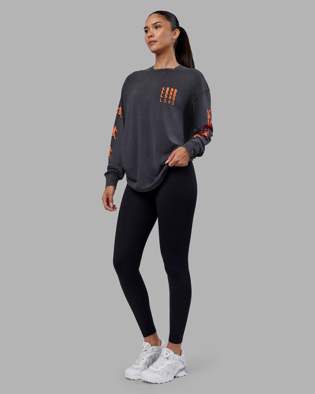 Woman wearing Inferno Journey FLXCotton Oversized Long Sleeve Tee - Washed Black-Ultra Orange | Model:Rhiley | Size:XS