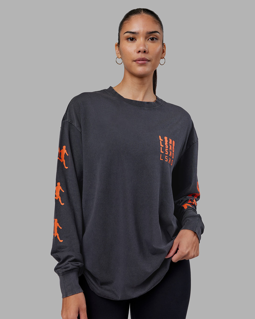 Woman wearing Inferno Journey FLXCotton Oversized Long Sleeve Tee - Washed Black-Ultra Orange | Model:Rhiley | Size:XS