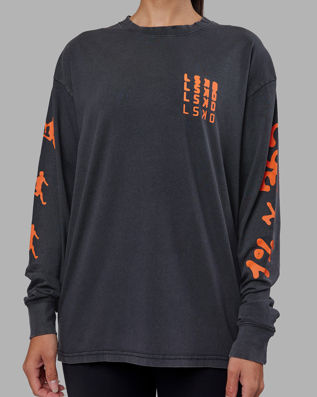 Woman wearing Inferno Journey FLXCotton Oversized Long Sleeve Tee - Washed Black-Ultra Orange | Model:Rhiley | Size:XS