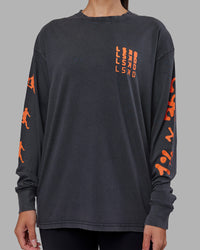 Woman wearing Inferno Journey FLXCotton Oversized Long Sleeve Tee - Washed Black-Ultra Orange | Model:Rhiley | Size:XS