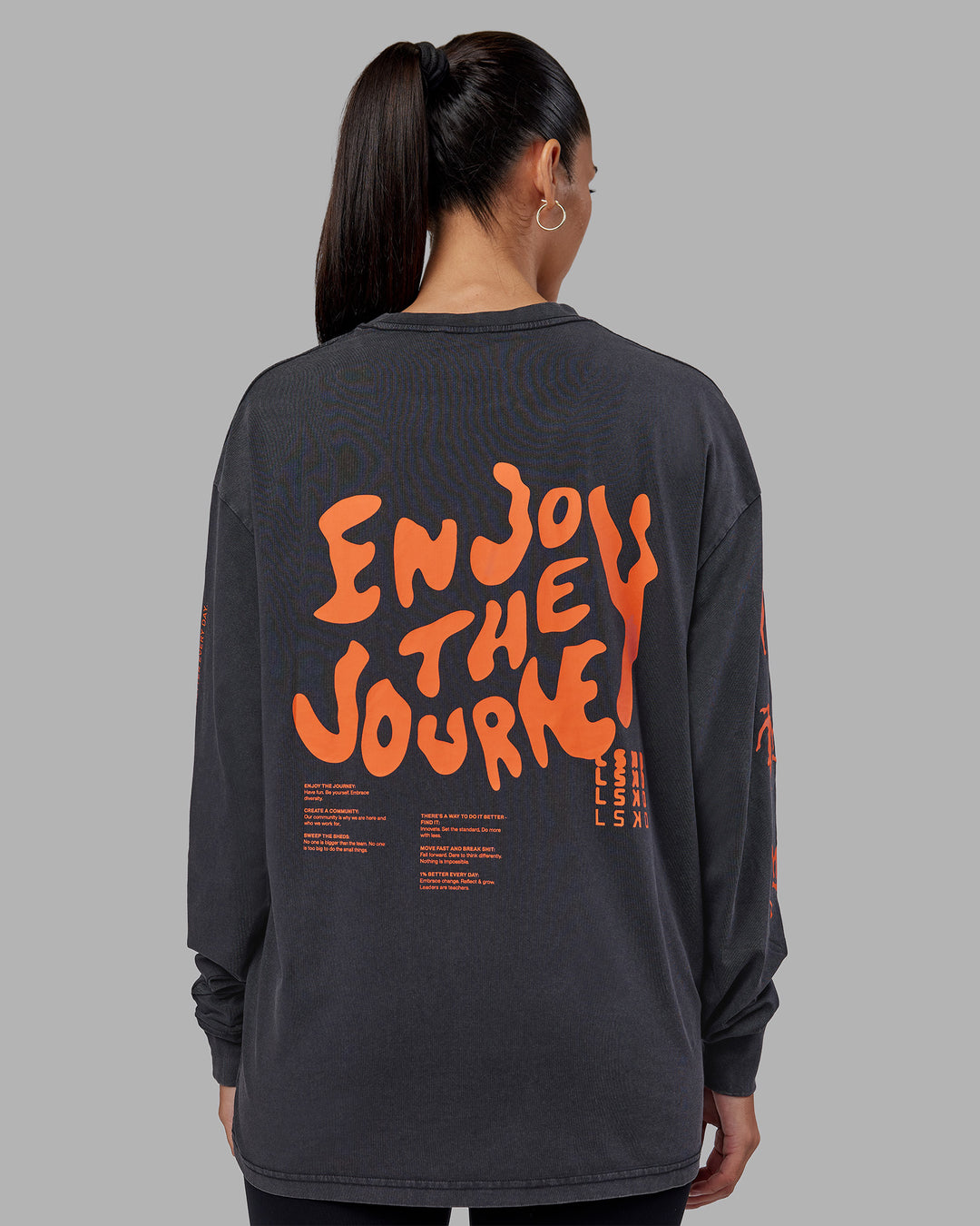 Woman wearing Inferno Journey FLXCotton Oversized Long Sleeve Tee - Washed Black-Ultra Orange | Model:Rhiley | Size:XS
