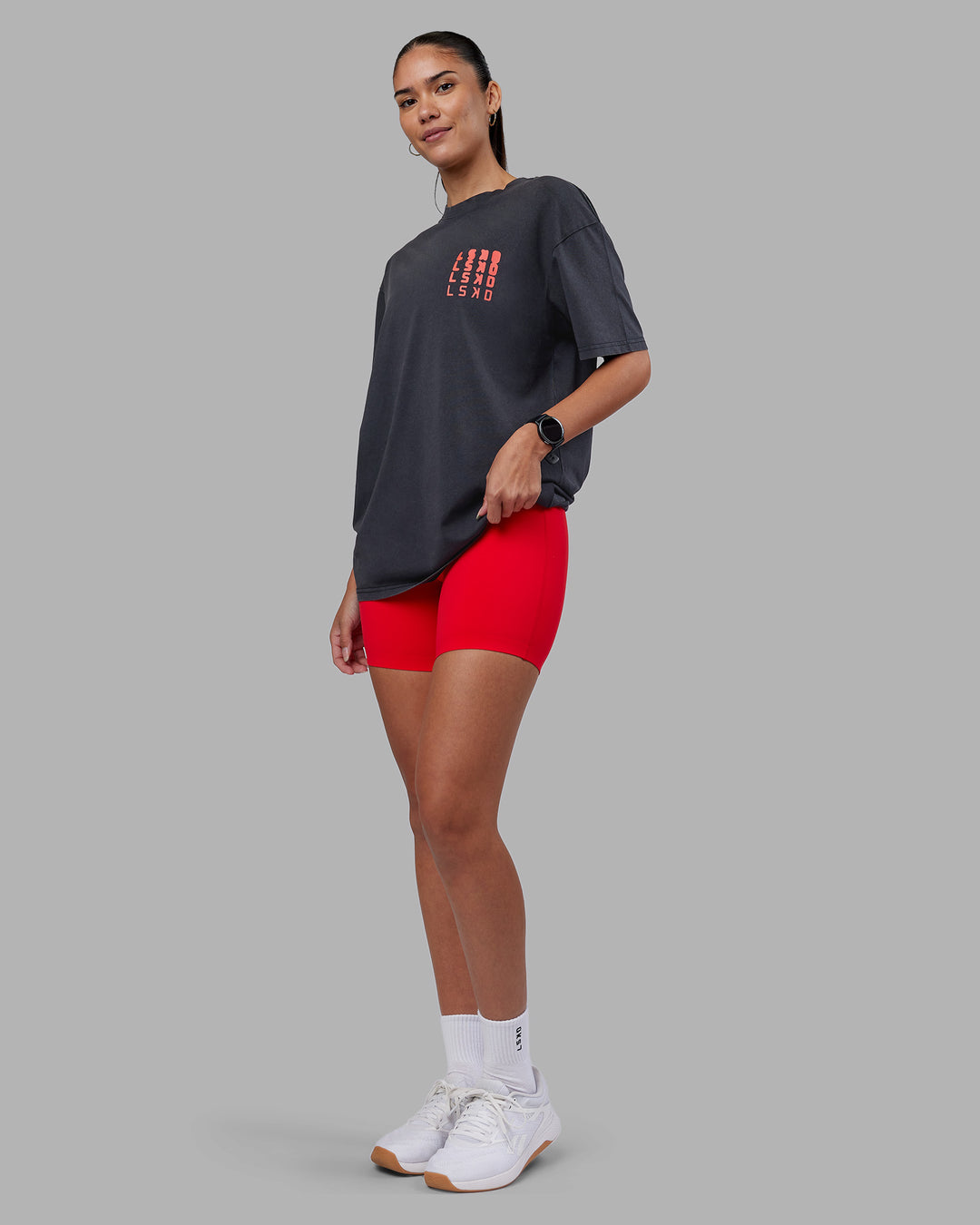 Woman wearing Inferno Journey FLXCotton Oversized Tee - Black Washed-Ultra Orange | Model:Rhiley | Size:XS