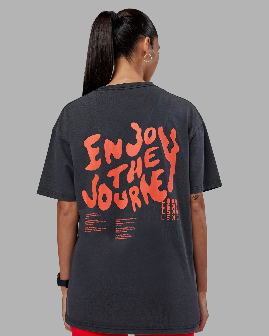 Woman wearing Inferno Journey FLXCotton Oversized Tee - Black Washed-Ultra Orange | Model:Rhiley | Size:XS