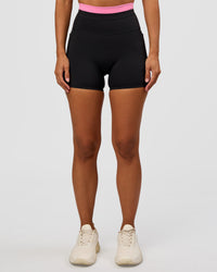 Woman wearing Liberate High-Rise 4" Short Pockets - Black-Candy Pink | Model:Brylee | Size:XS