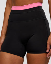 Woman wearing Liberate High-Rise 4" Short Pockets - Black-Candy Pink | Model:Brylee | Size:XS