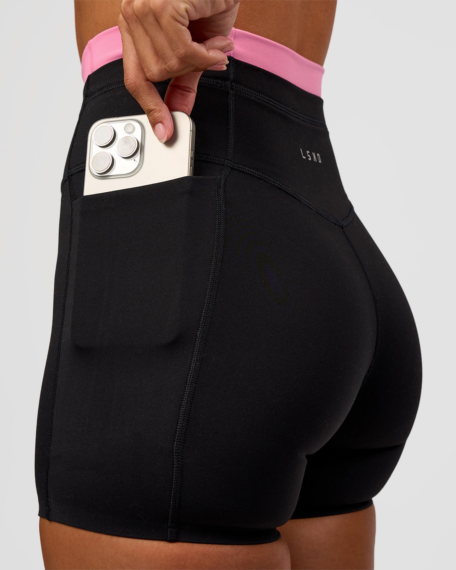Woman wearing Liberate High-Rise 4" Short Pockets - Black-Candy Pink | Model:Brylee | Size:XS