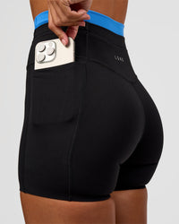 Woman wearing Liberate High-Rise 4" Short Pockets - Black-Palace Blue | Model:Brylee | Size:XS | Thumbnail Index: 1