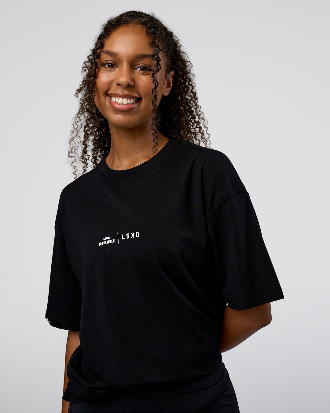 Woman wearing Movember 2025 FLXCotton Oversize Tee - Black | Model:Jordan | Size:XS
