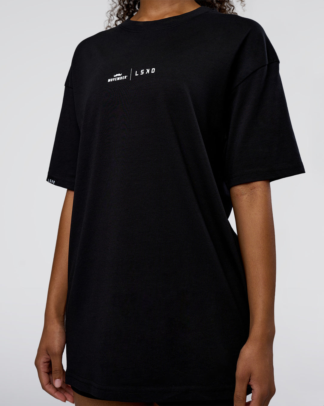 Woman wearing Movember 2025 FLXCotton Oversize Tee - Black | Model:Jordan | Size:XS