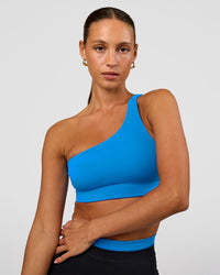Woman wearing Muse Asymmetric Sports bra - Palace Blue | Model:Brylee | Size:XS | Thumbnail Index: 0