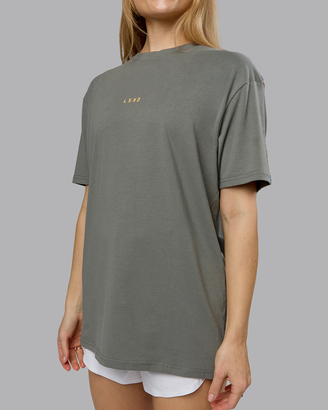 Woman wearing On Repeat FLXCotton Oversized Tee - Graphite-Warm Apricot | Model:Emilie | Size:XS