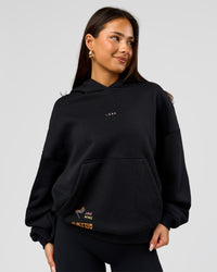 Woman wearing Pride Sticker Boxy Hoodie - Black | Model:Bianca | Size:XS