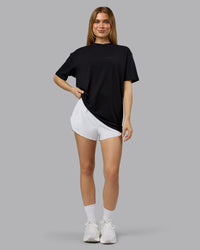 Woman wearing RUN CLUB FLXCotton Tee Oversize - Black-Reflective | Model:Emilie | Size:XS