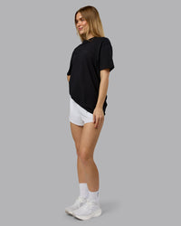 Woman wearing RUN CLUB FLXCotton Tee Oversize - Black-Reflective | Model:Emilie | Size:XS