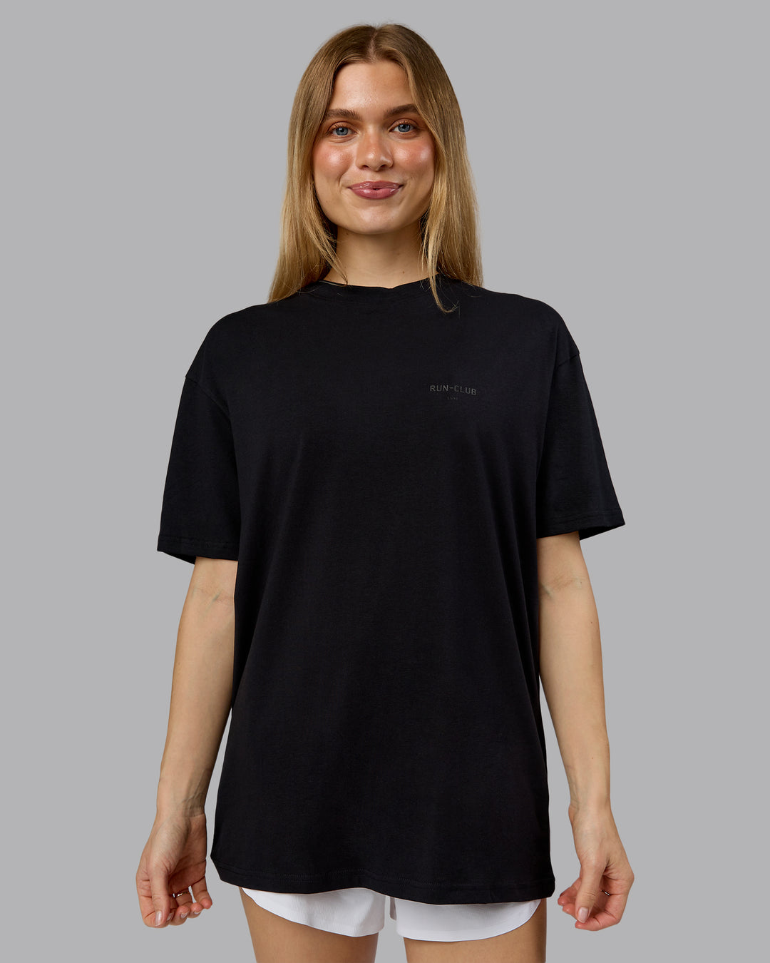 Woman wearing RUN CLUB FLXCotton Tee Oversize - Black-Reflective | Model:Emilie | Size:XS