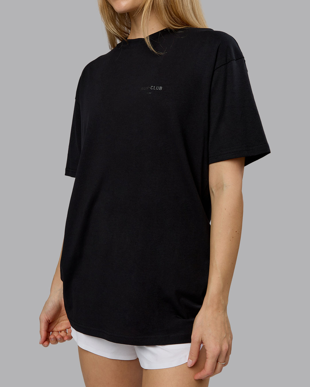 Woman wearing RUN CLUB FLXCotton Tee Oversize - Black-Reflective | Model:Emilie | Size:XS