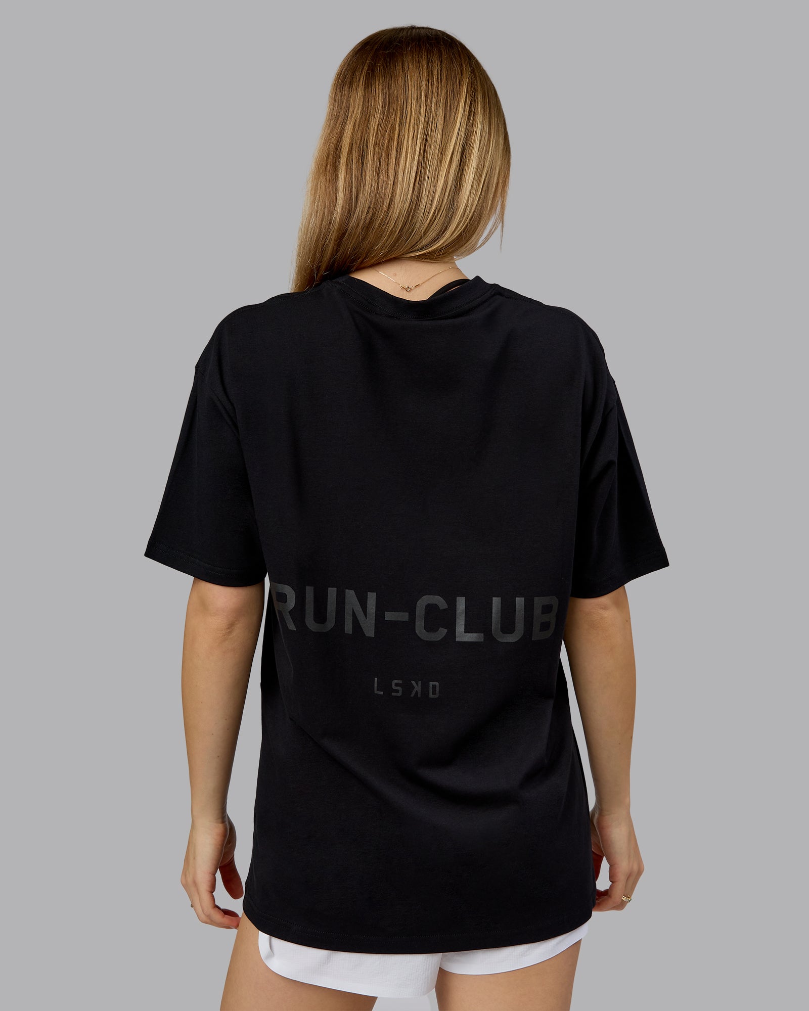 Woman wearing RUN CLUB FLXCotton Tee Oversize - Black-Reflective | Model:Emilie | Size:XS