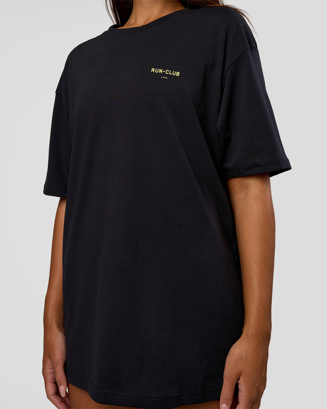 Woman wearing RUN CLUB FLXCotton Tee Oversize - Black-Yellow Fizz | Model:Kirstyn | Size:XS