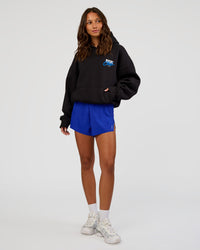 Woman wearing Run Club Script Oversized Hoodie - Black-Palace Blue | Model:Dakota | Size:XS