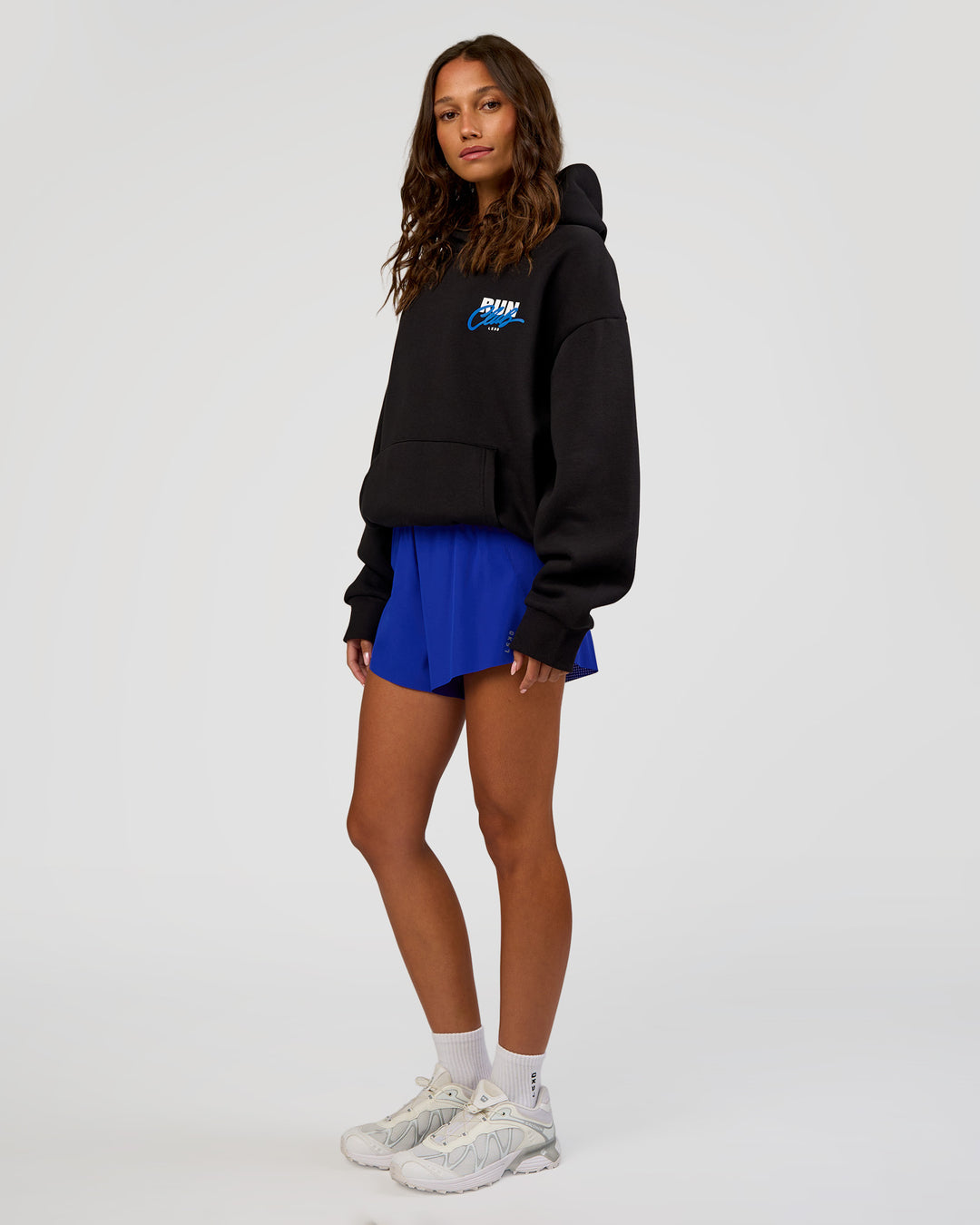 Woman wearing Run Club Script Oversized Hoodie - Black-Palace Blue | Model:Dakota | Size:XS