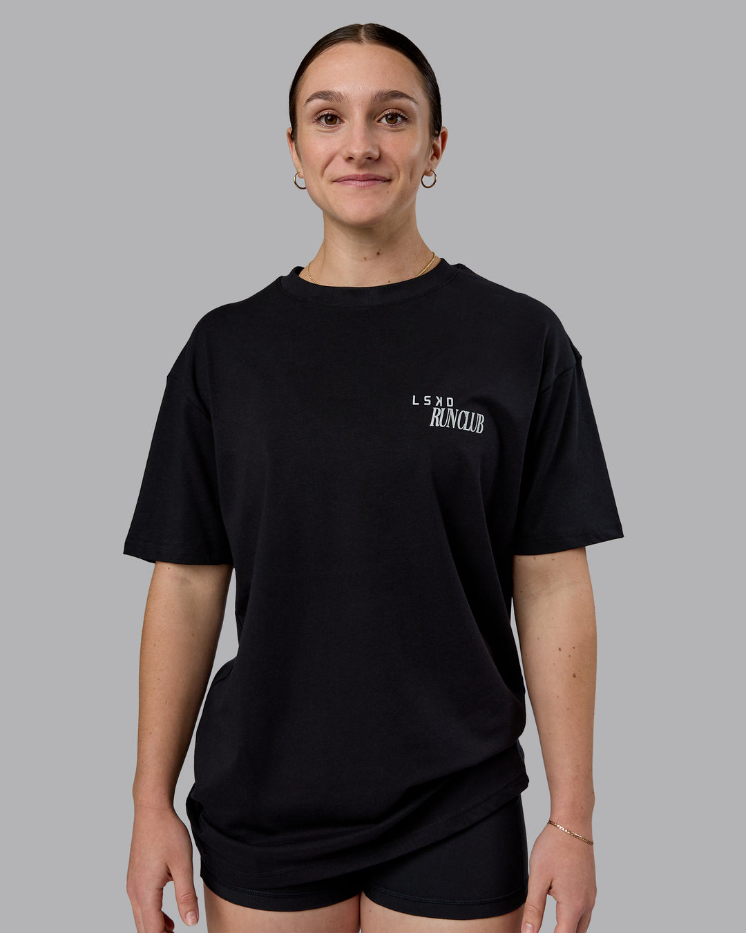 Woman wearing Run Love FLXCotton Oversized Tee - Black-Reflective | Model:Sav | Size:XS