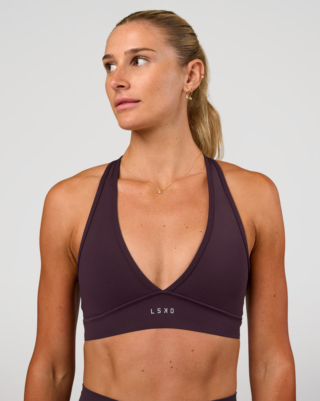 Woman wearing Stamina Sports Bra - Midnight Plum | Set:true | Angle:front | Model:Emelia | Size:XS