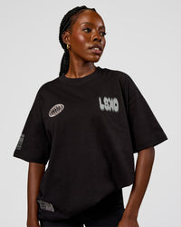 Woman wearing Static Grit Heavyweight Oversized Tee - Black-Alloy | Model:Ellie | Size:XS
